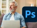 Uśmiechnięty mężczyzna z laptopem i logo Photoshop.