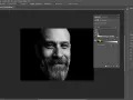 Portret mężczyzny w czerni i bieli z widocznym panelem korekty tonalnej w Photoshopie.