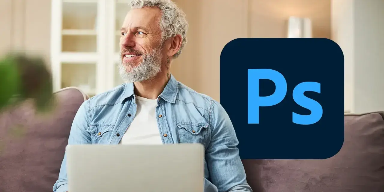 Uśmiechnięty mężczyzna z laptopem i logo Photoshop.