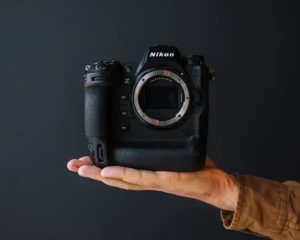 Dłoń trzyma profesjonalny aparat Nikon z9. Bez obiektywu, gotowy do uchwycenia niezwykłych chwil.