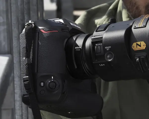 Profesjonalny aparat Nikon z obiektywem i adapterem FTZ II gotowy do akcji.
