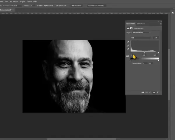 Portret mężczyzny w czerni i bieli z widocznym panelem korekty tonalnej w Photoshopie.